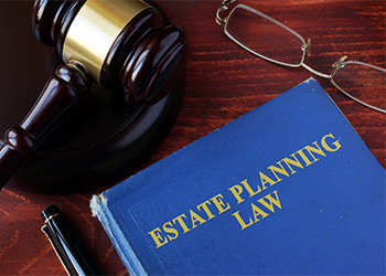 Gavel, glasses, and Estate Planning Law book on a table