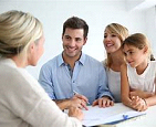 Adults and children at a table looking at paperwork