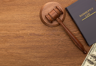 Top View of Money, Bankruptcy Law Book and Gavel on Wooden Background