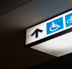 Lighted disability sign with an upward pointing arrow