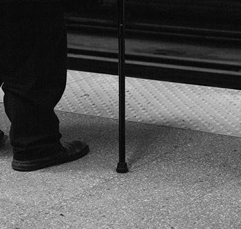 Black and white image of man waiting for the bus