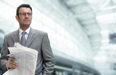 Man in Gray Suit Holding a Newspaper