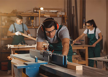 Professional carpenter working with surface planer