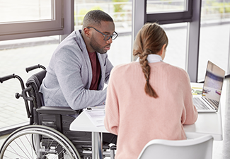 Man in a Wheelchair Speaking with a Woman