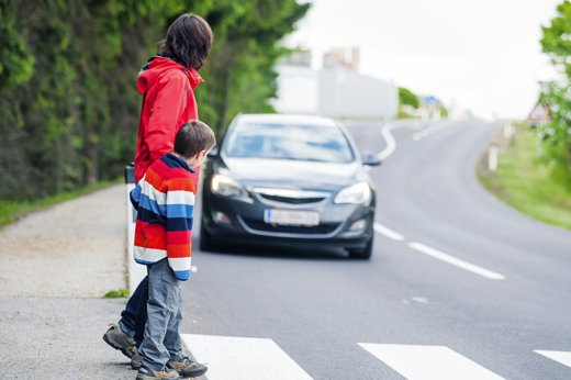 Boy walking across street with oncoming car