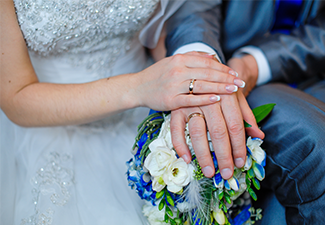 Hands of the bride and groom with the rings lying on the bridal