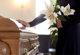 Woman with Lily Flowers and Coffin at Funeral