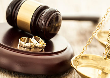 Divorce concept with gavel and wedding rings