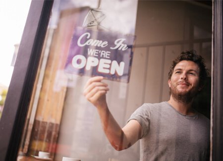 Manin store window flipping open sign