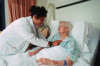 nurse checking on elderly woman