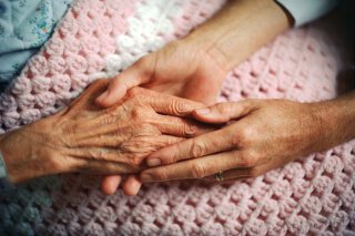 person holding elderly persons hands