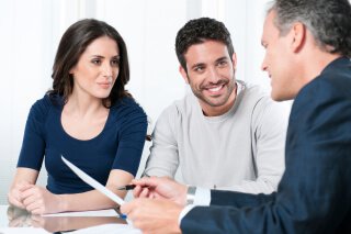 couple reviewing documents with a man in a suit