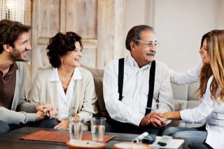 young couple talking to an older couple