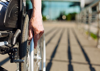 Aged strong lady rolling the wheelchair