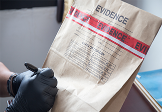 Hand in Glove Writing on Evidence Bag and Seal by Red Tape.