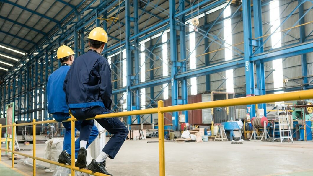 Two men in hardhats in a warehouse