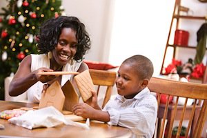 Happy mother and son building gingerbread house