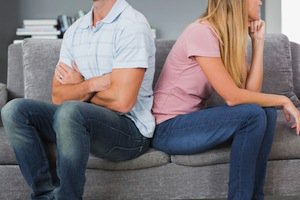 Couple facing away from each other and crossing arms