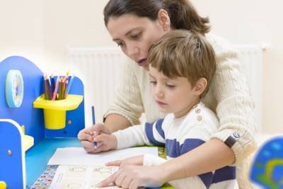 Mother helping son write