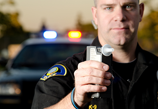 Policeman Holding a Breathalyzer for DUI Test