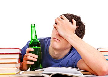 Person holding bottle sitting with books