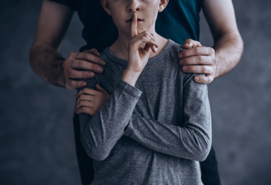 Teenage Boy Putting his Index Finger on his Lip