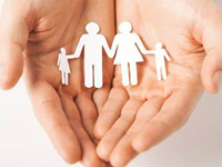 Hands holding paper cut out of a family