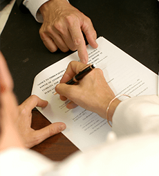 Two Men Inspecting a Contract on A Table