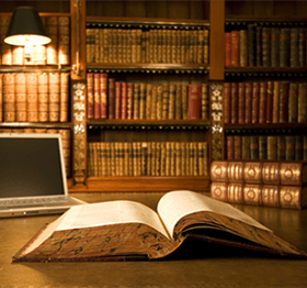 Open Book on A Desk in Front of A Bookshelf