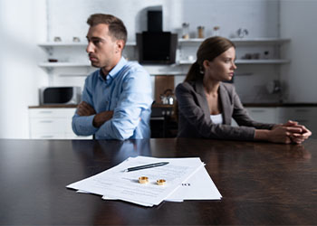 couple sitting at table with divorce documents