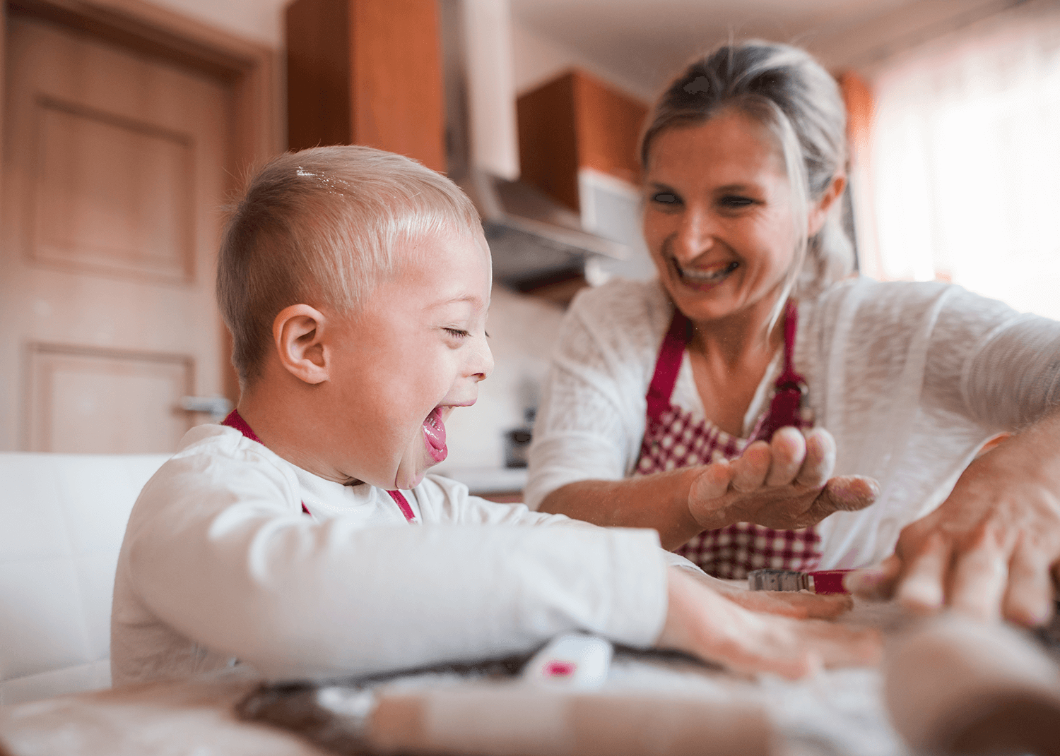 a child with downs syndrome baking with their mother