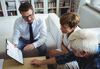 Senior couple planning their investments with financial advisor.