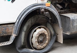 Flat tire of an old fragment of a rusty broken truck