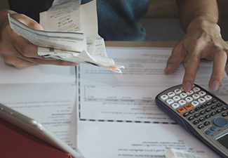 Man using calculator for calculate expenses accounts.