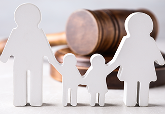 Figure in shape of people and wooden gavel on light table.