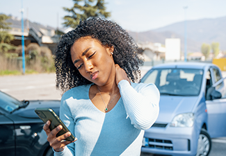 Black woman calling insurance support after car crash.