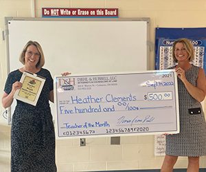 Heather Clements posing with large check and plaque