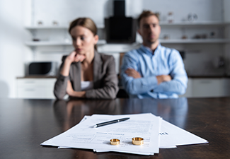 selective focus of couple sitting at table with divorce documents