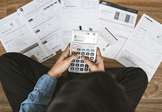 Top View Man Sitting on The Floor Calculating His Expense