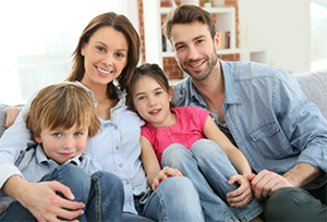 Family sitting together and smiling getting their picture taken 