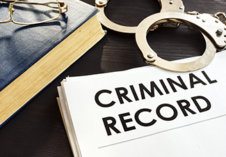 Criminal Record and Handcuffs on A Desk