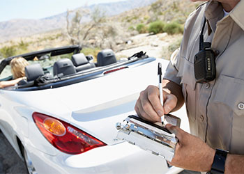 police officer writing traffic ticket to woman