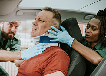 Paramedic placing a cervical collar to an injured man