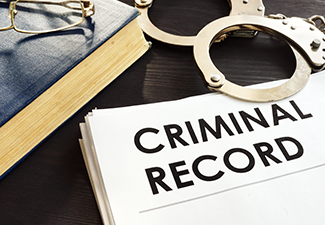 Criminal Record and Handcuffs on A Desk