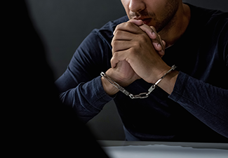 Criminal Man with Handcuffs in Interrogation Room