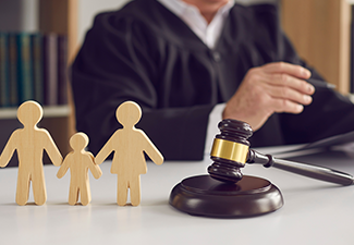 Gavel, sound block and small wooden figurines of husband.