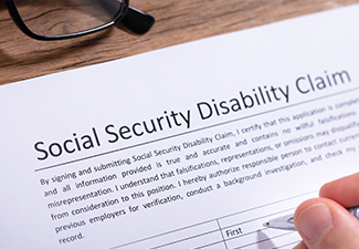 Person Filling Social Security Disability Claim Form.