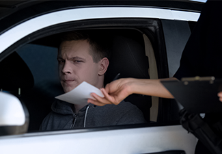 Police woman giving fine receipt to driver on road.