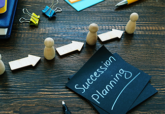 Succession planning sign and figurines with arrows.