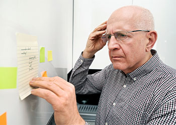 Elderly man with dementia looking at notes